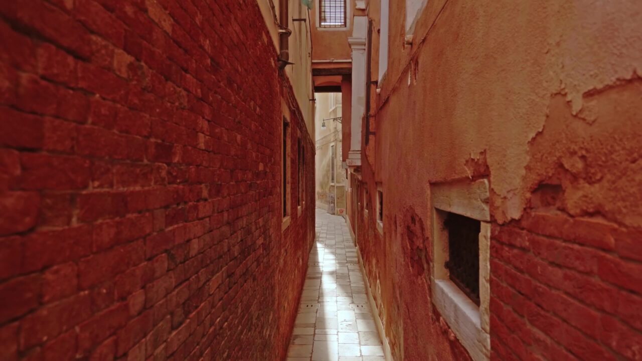 Calle veneziana stretta tra edifici antichi