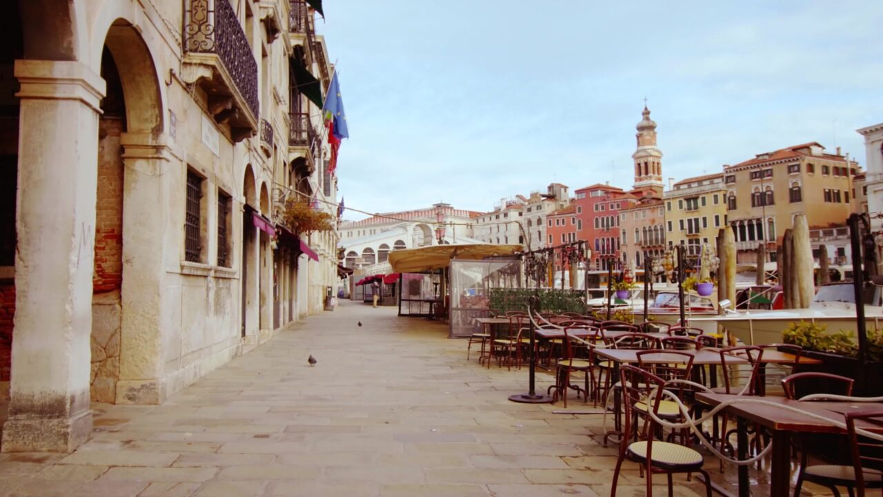 Strada vuota di Venezia con tavoli del bar