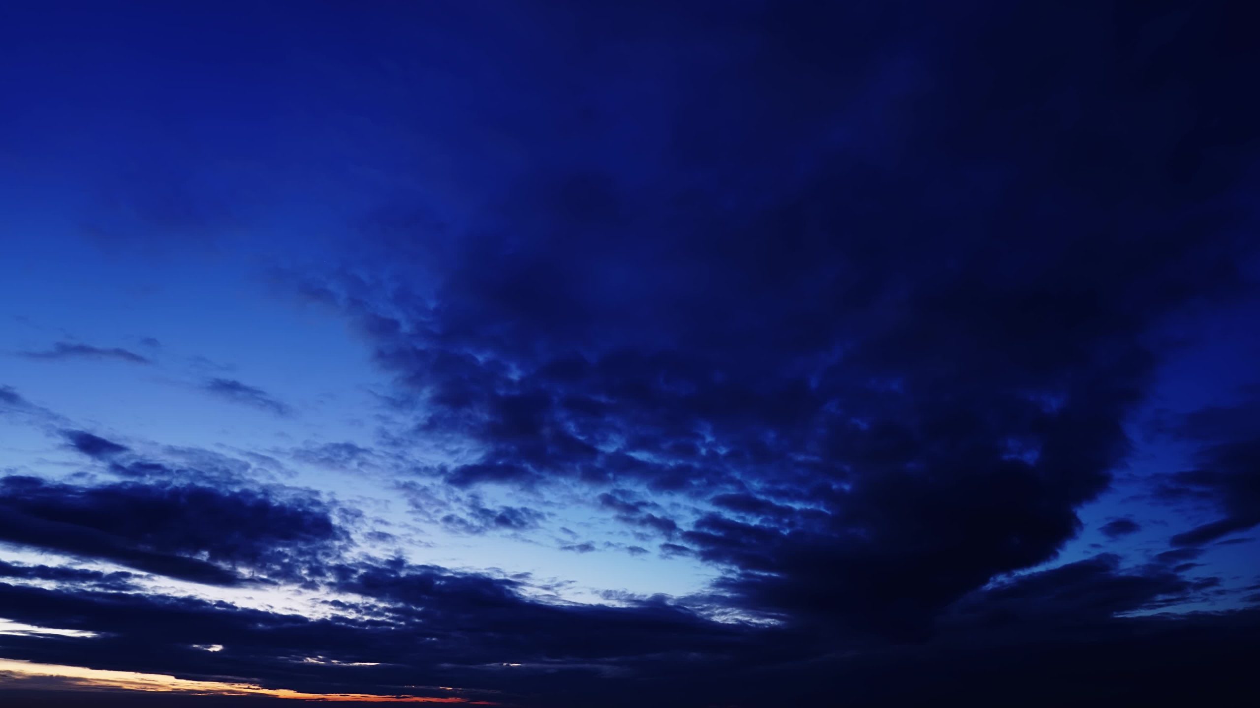 Incredibili nuvole scure fluttuano lentamente attraverso il colorato cielo serale