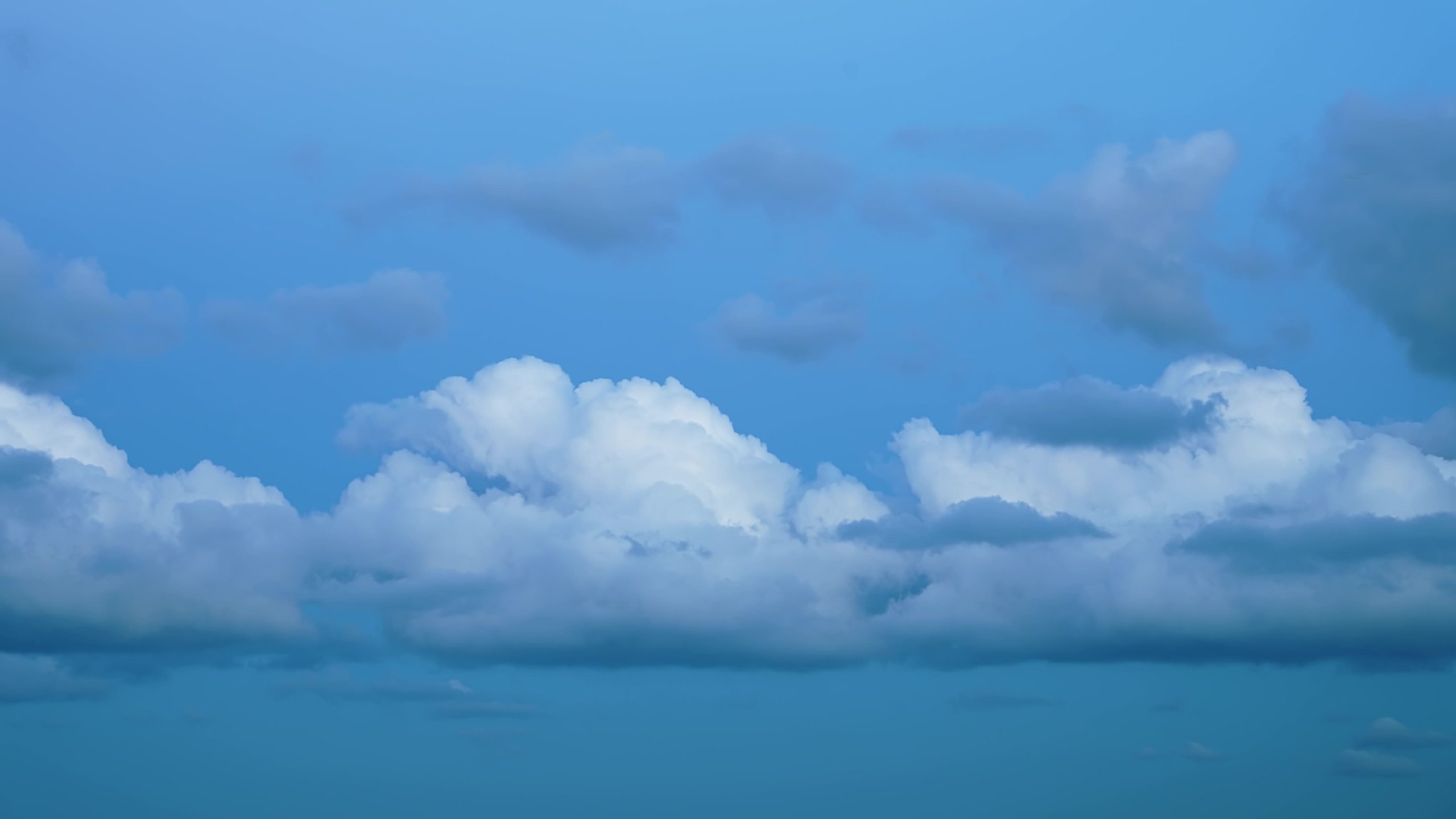 Group of fluffy clouds float fast across blue sky Timelapse