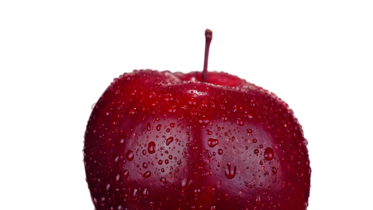 Grande mela rossa dolce con gambo piccolo e gocce d’acqua limpide
