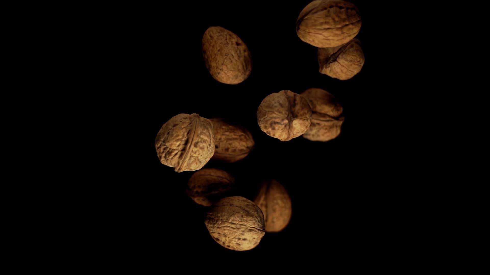 Healthy walnuts with shells of brown colour fall under light
