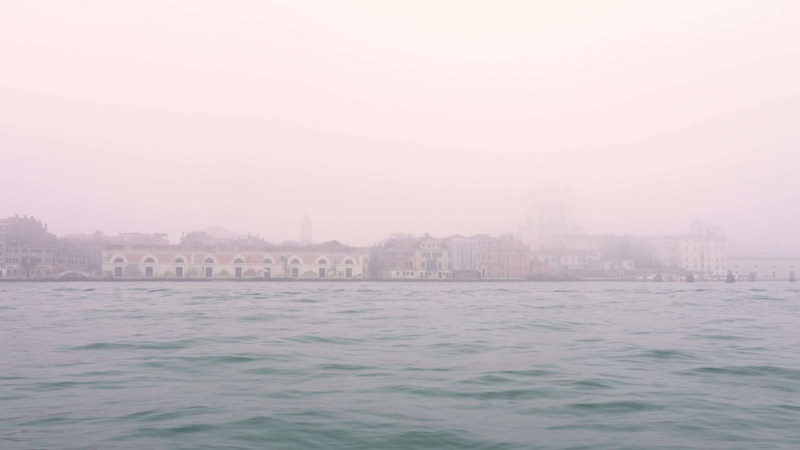Acqua lagunare veneziana contro il centro storico nella nebbia