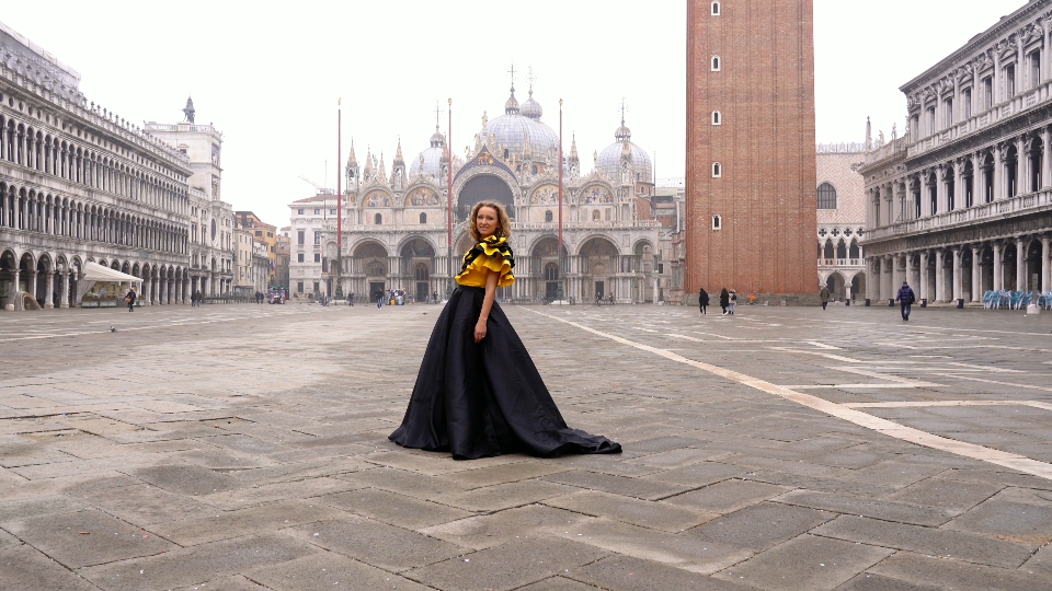 Bella signora in abito lungo posa in piazza San Marco deserta