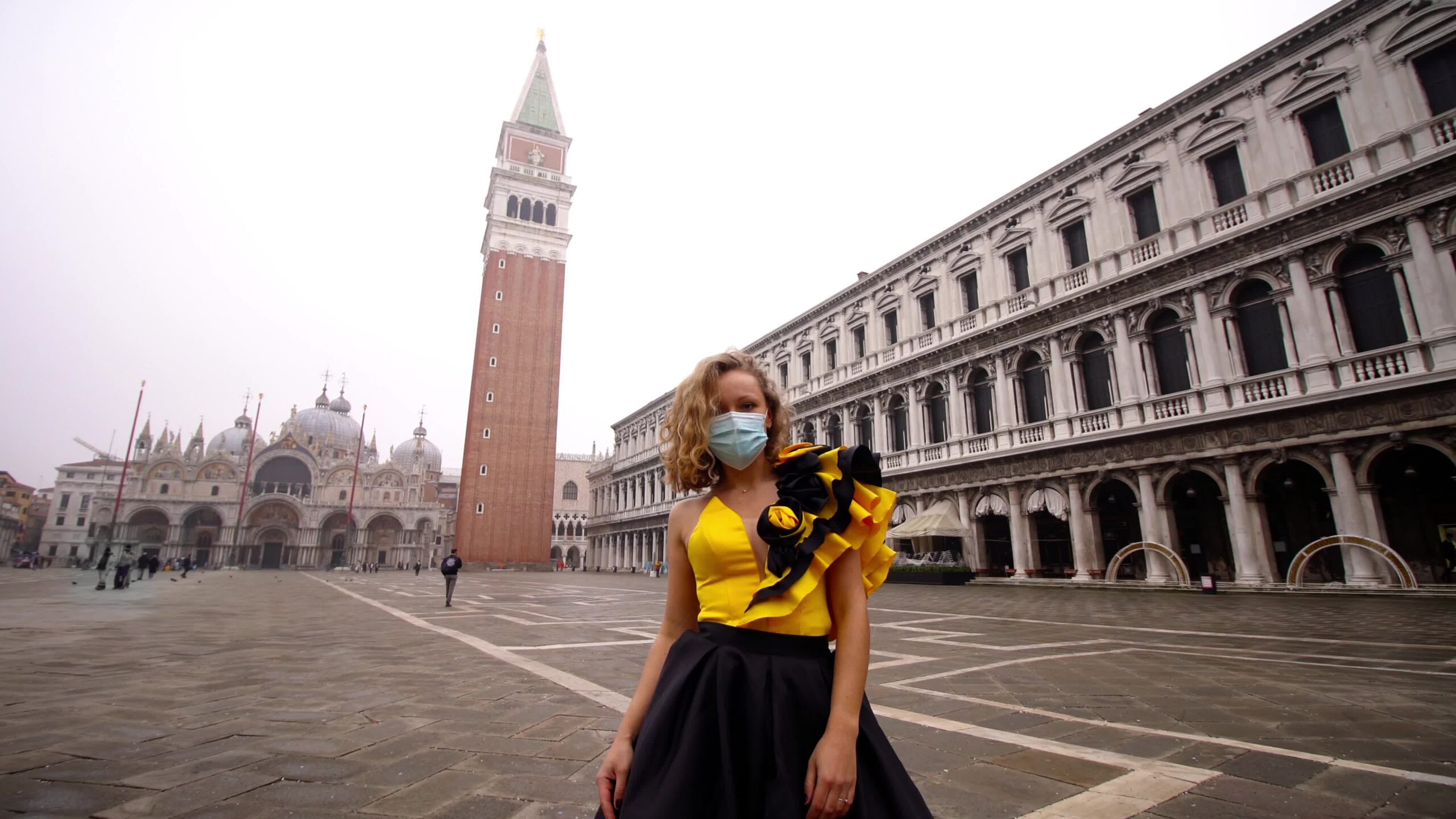 Modello in abito e maschera medica posa su piazza venezia vuota