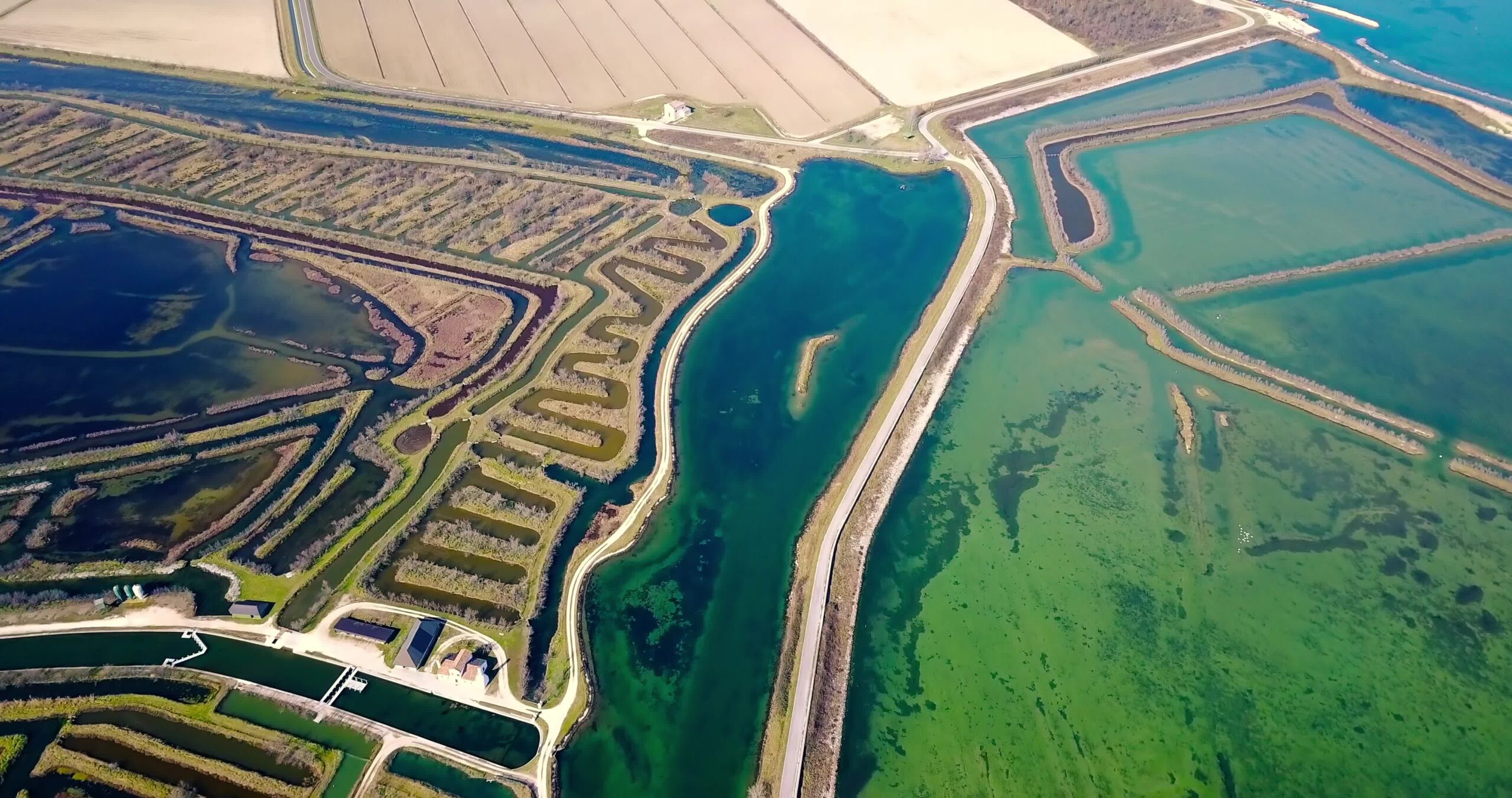 Boundless dry fields near bright turquoise Venetian lagoon