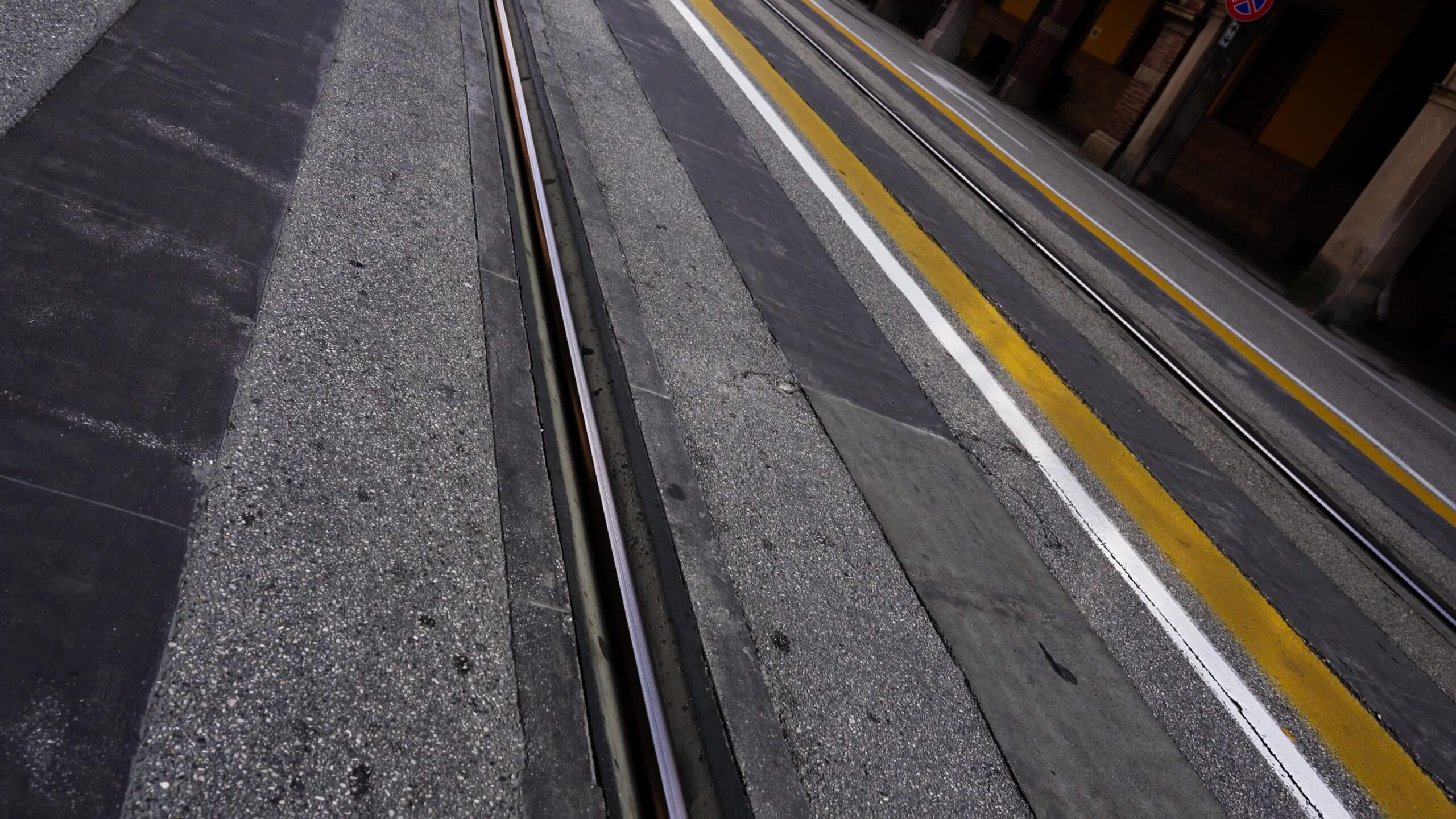 Rotaie parallele della linea del tram su un’ampia strada asfaltata in città