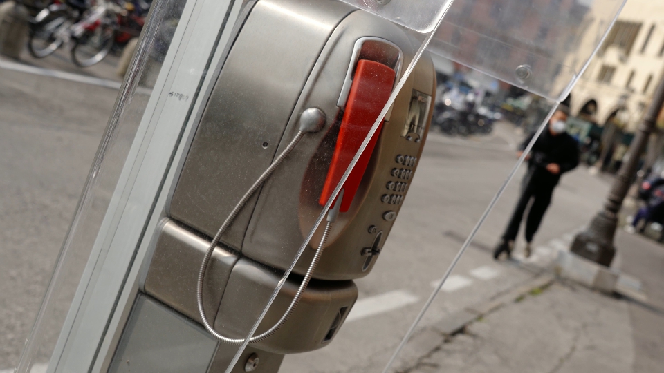 Piccola cabina telefonica contro persona in maschera su scooter e auto