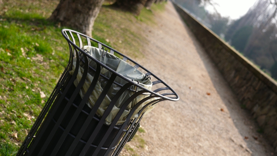 Elegante bidone della spazzatura in metallo a cilindro nel parco cittadino locale