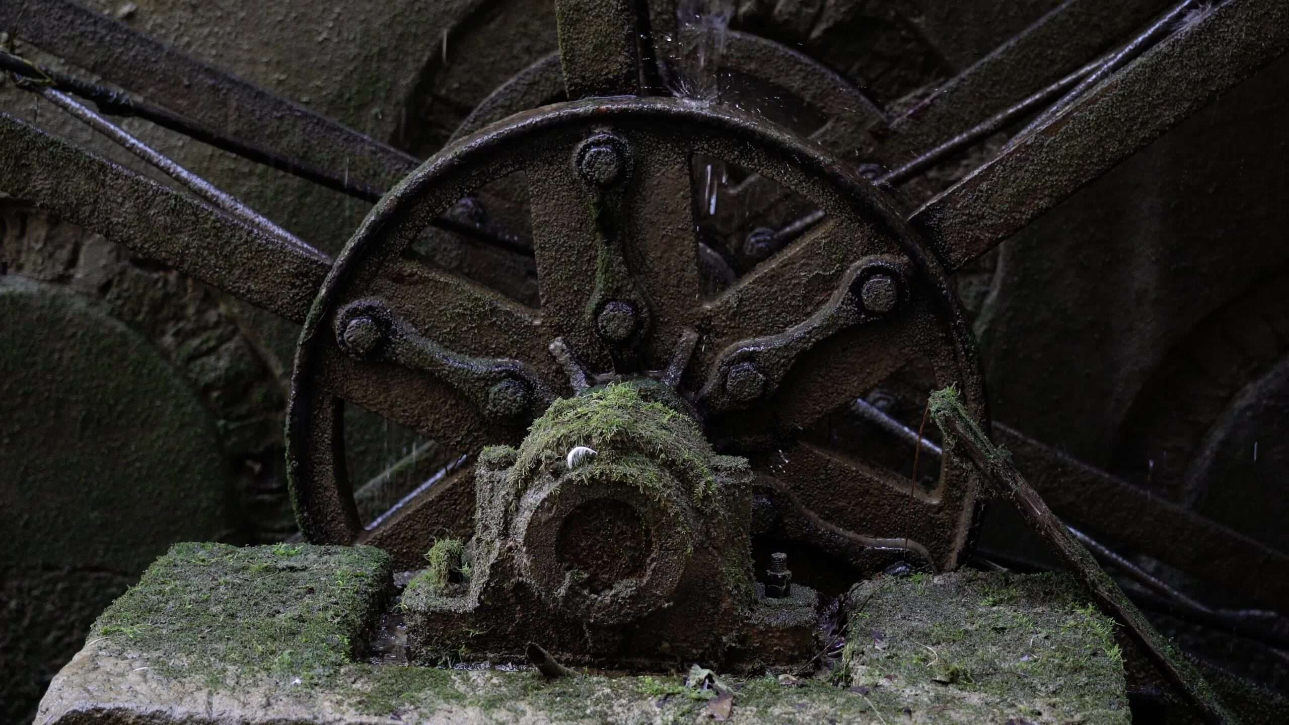 Il meccanismo arrugginito della ruota idraulica ruota su vecchi supporti in pietra