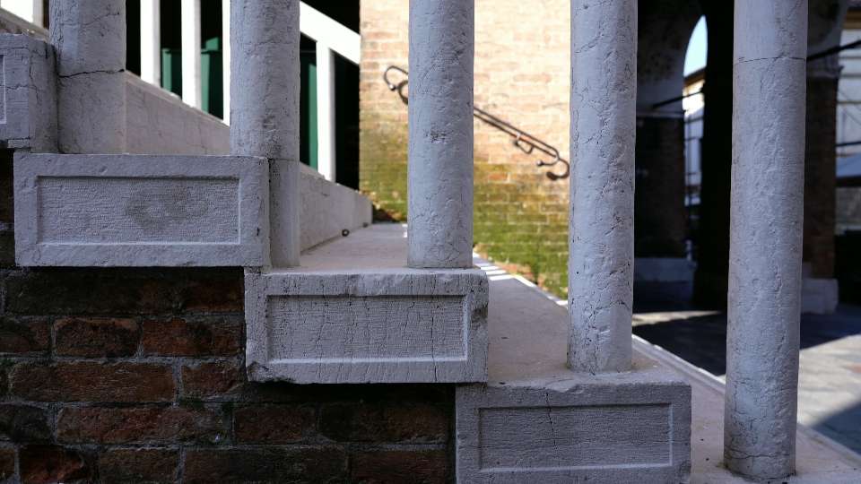 Scale in cemento bianco con grandi colonne come corrimano