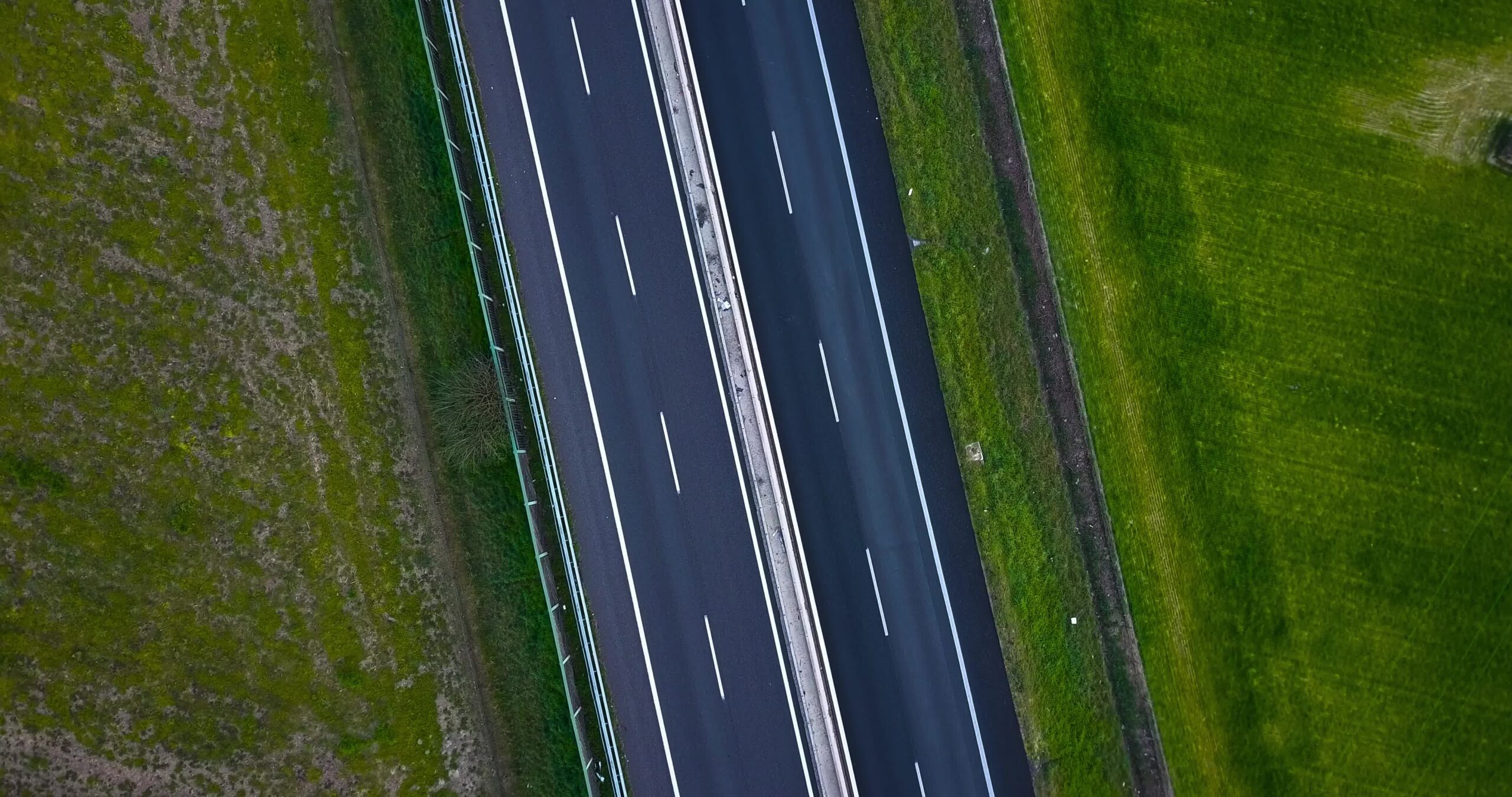 Strada asfaltata divisa con strisce bianche nella zona rurale
