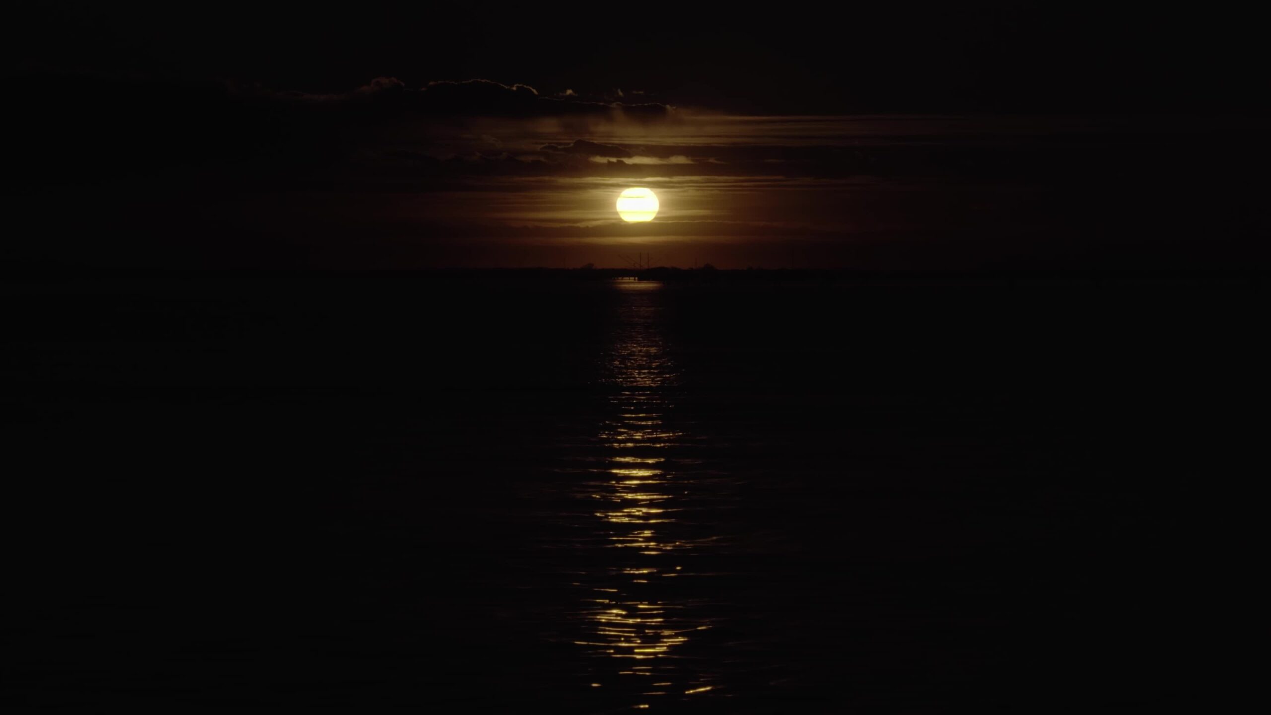 La luce del disco lunare si riflette sull’acqua creando un percorso nel mare