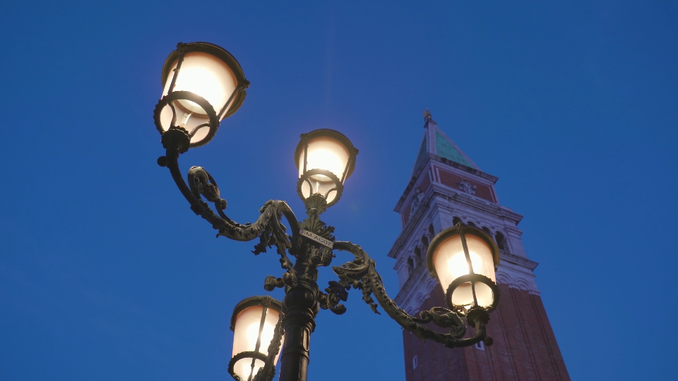 Street lantern against high tower at Saint Mark Square