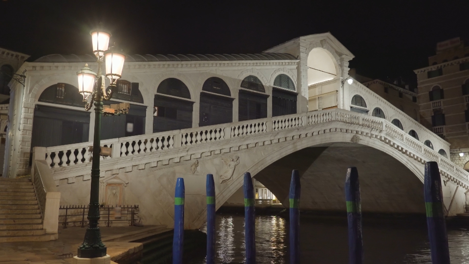 Ponte di Rialto ad arco illuminato sul Canal Grande di notte