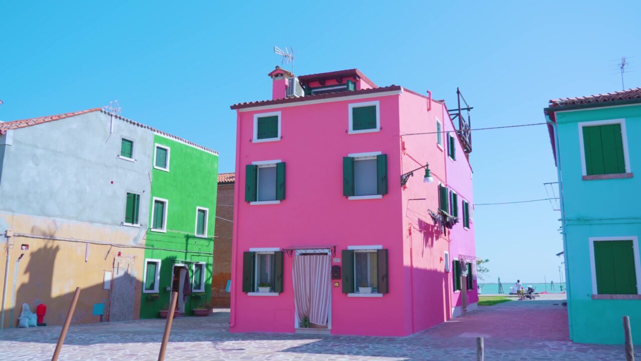 Strade senza uomini di Burano con la casa rosa ordinata alla luce del sole