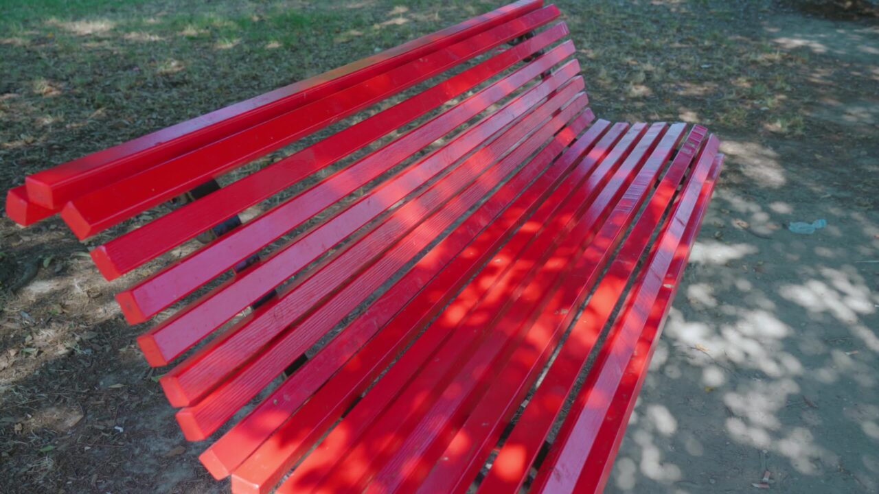 Panchine rosse dipinte a colori vivaci si trovano nel parco cittadino di Burano