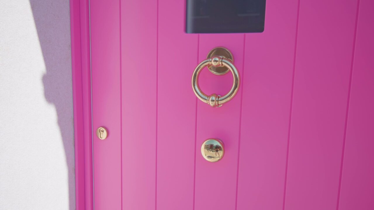 Maniglia e spioncino sulla porta rosa brillante di casa a Burano