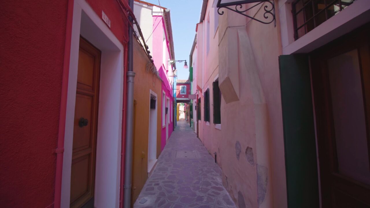 Stradina stretta tra case multicolori che porta alla strada