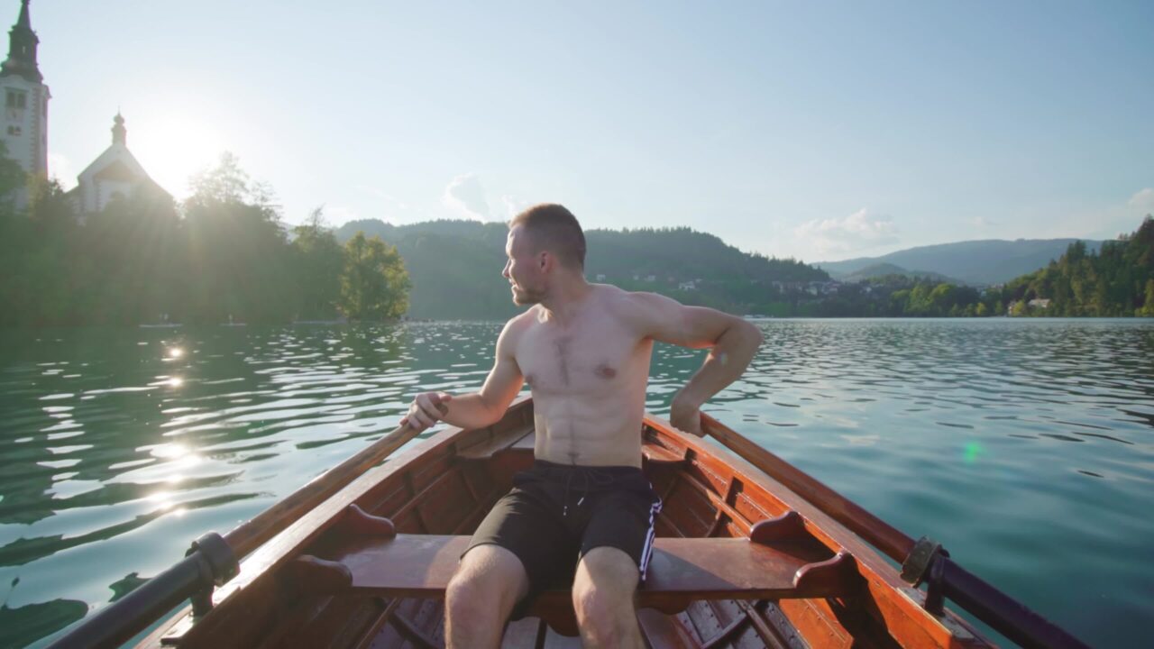 Uomo seduto in barca di legno  sul lago