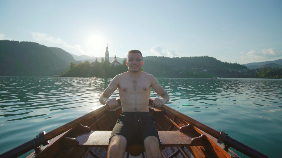 Uomo in barca di legno sul lago