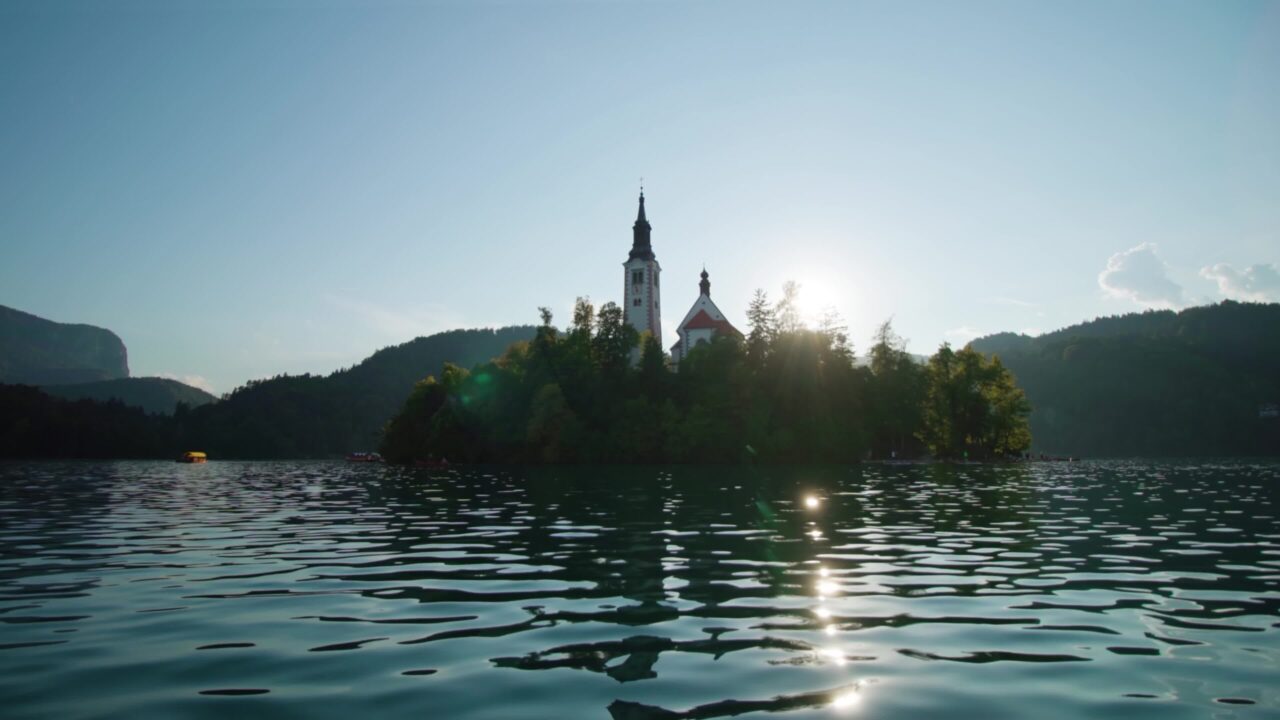 Isola con chiesa e foresta alla luce del sole sul lago di Bled