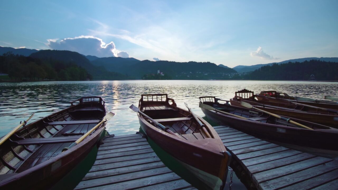 Barche di legno ormeggiate al tramonto sul lago di Bled