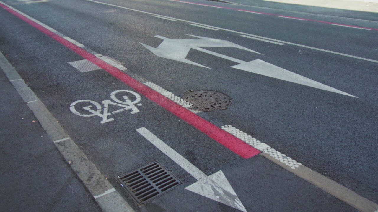 Pista ciclabile lungo strada asfaltata con segnaletica