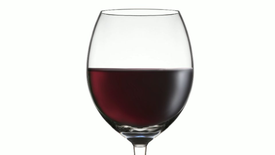 Empty goblet filling up with red wine on white background