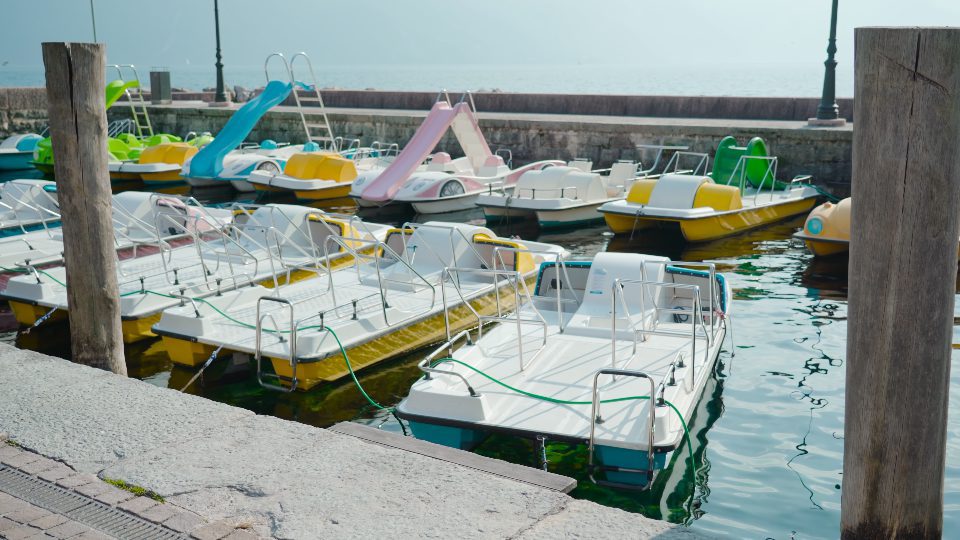 Colorate barche da pesca e da tour ormeggiate nel porto del lago di Garda