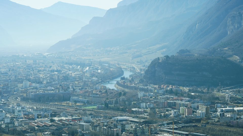 City Trento with small buildings and river against mountains