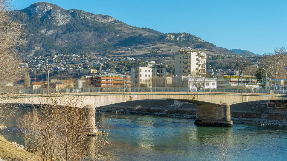 Bridge with heavy traffic connects parts of old town Trento