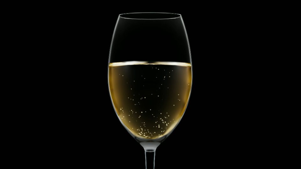 Bicchiere di cristallo con spumante bianco su fondo nero