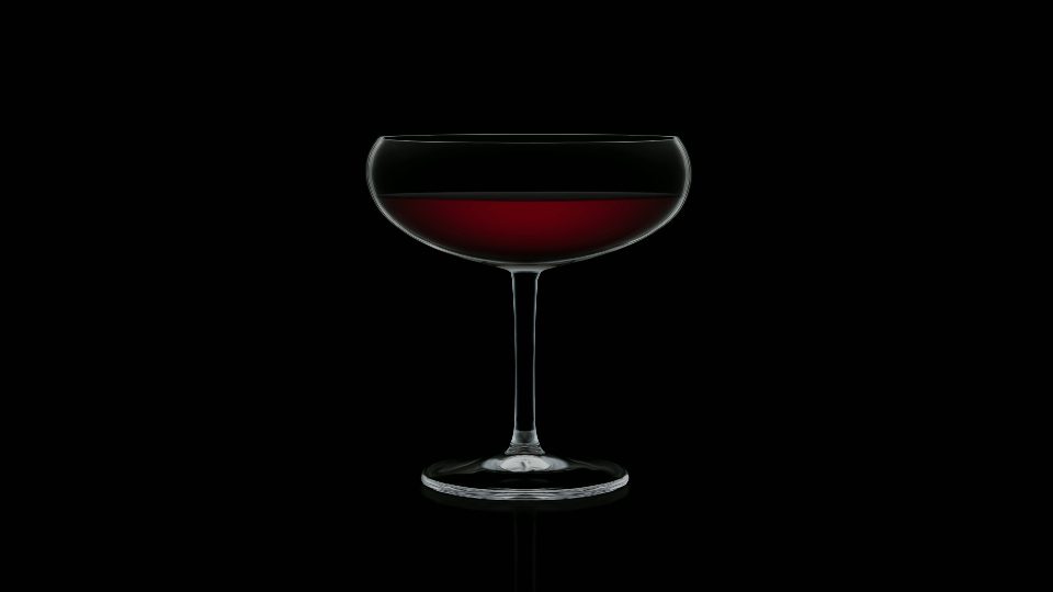 Il bicchiere vuoto di cristallo si riempie di gustosa bevanda alcolica