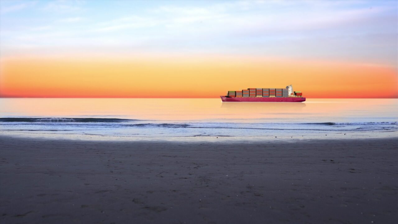 La nave da carico trasporta container in mare al tramonto