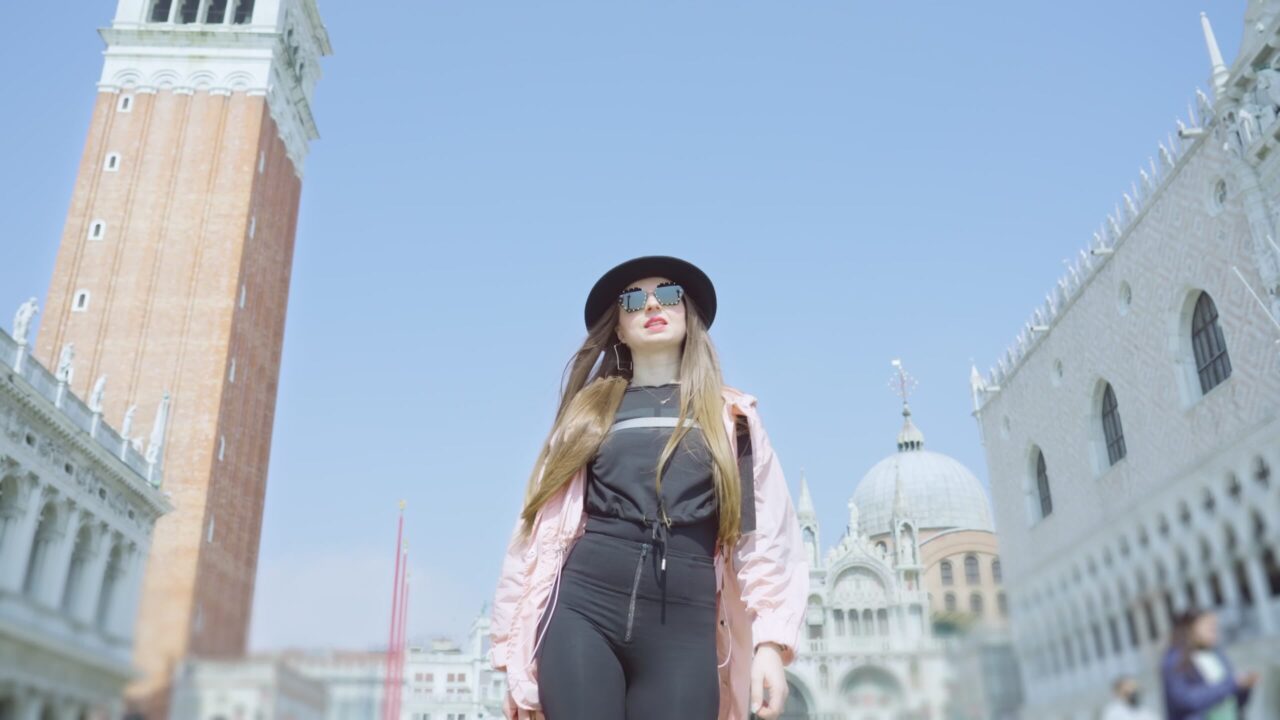 Elegante signora con cappello cammina in Piazza San Marco a Venezia