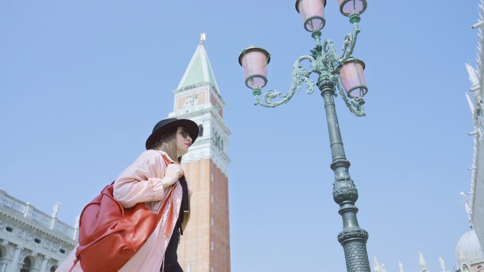 La donna passa davanti a una lanterna di strada vintage in Piazza San Marco