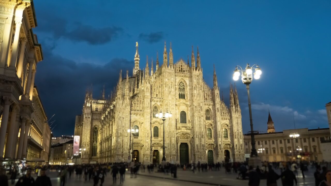 Famous Milan Cathedral on busy central square at twilight