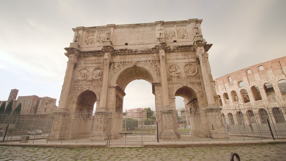 Ancient Triumphal arch built against Colosseum in Rome