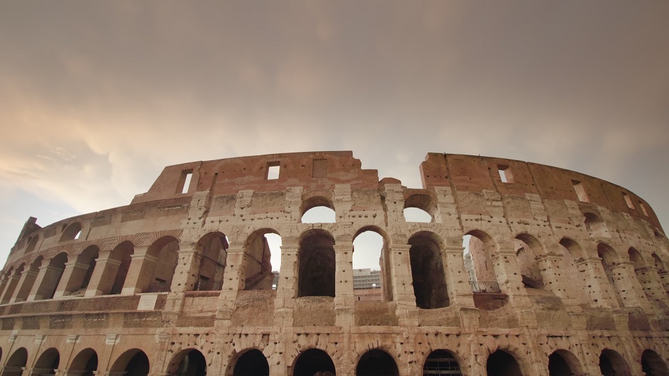 Ancient Colosseum against cloudy sky in center of Rome