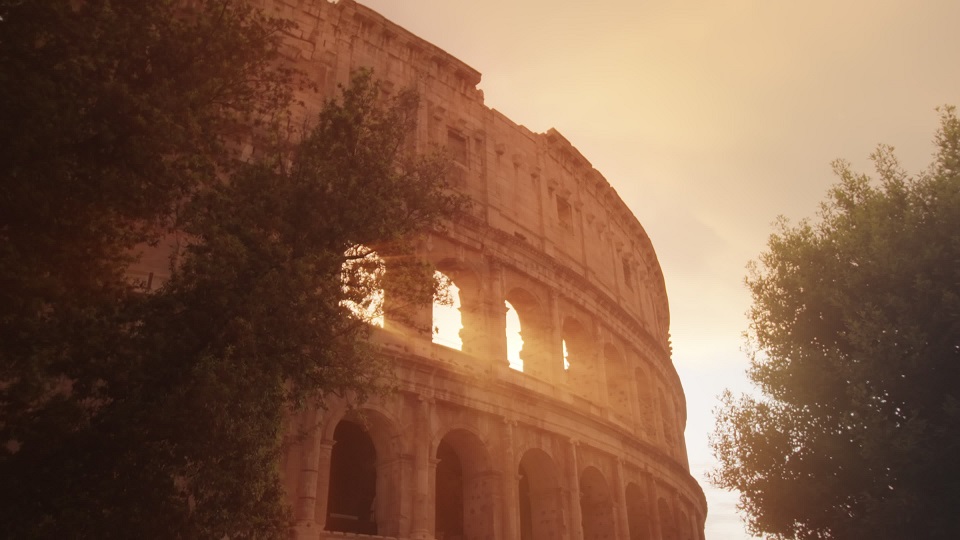 Bright sunlight breaks through arches of ancient Colosseum