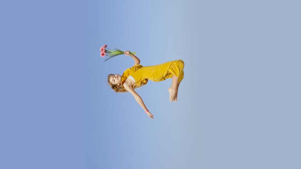 Girl in jump in slow motion with flowers in hand