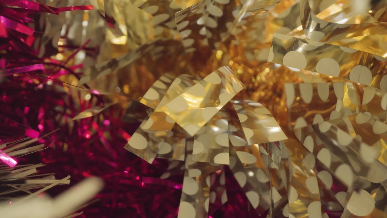 Motion though colorful foil Christmas tree tinsels in studio