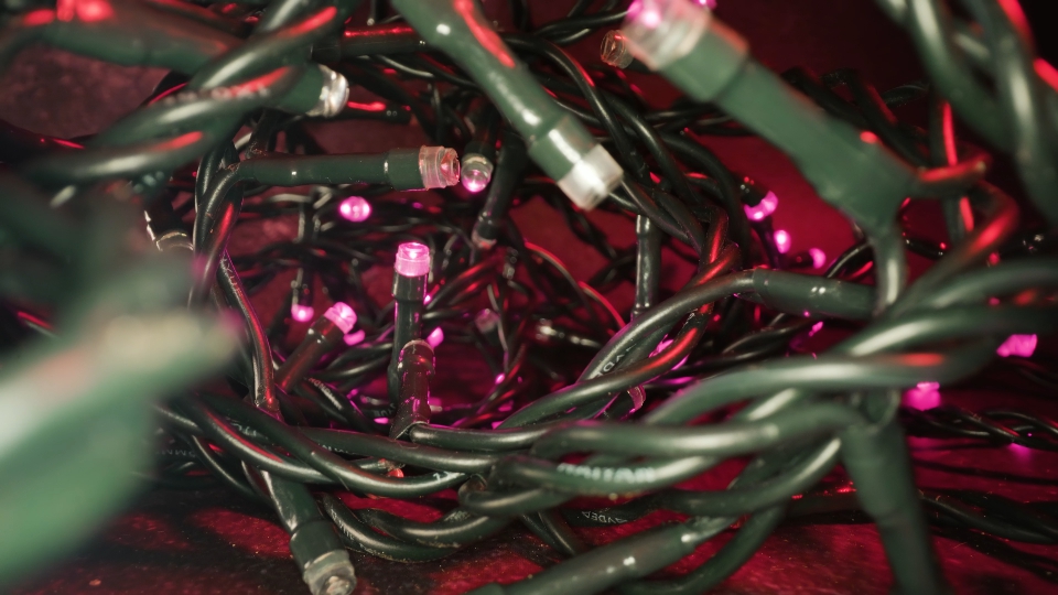 Tangled fairy lights coil with glowing lamps at Christmas