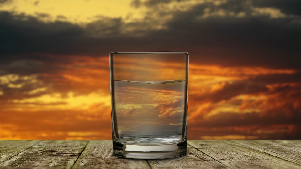 Glass with water with sunset sky